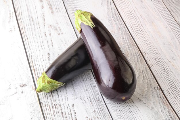 Twee verse rijpe zwarte aubergines over houten ondergrond om te koken