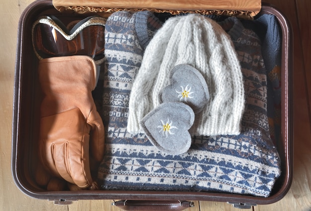 Twee vilten harten geplaatst in een koffer met warme kleding