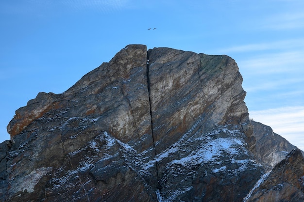 Twee vogels vliegen over een gebarsten rots kaap khoboy prachtige winter landschap van bevroren Baikal meer