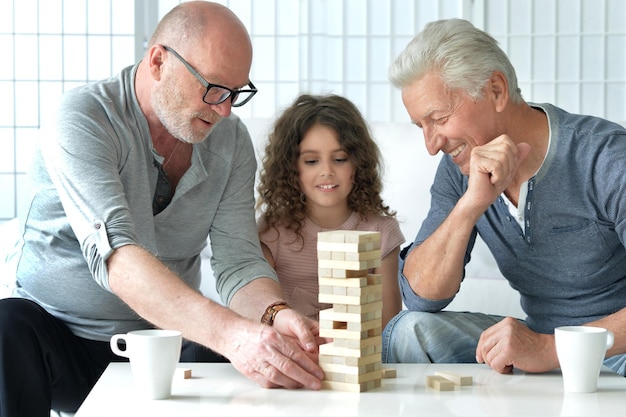 Foto twee volwassen mannen spelen jenga met kleindochter