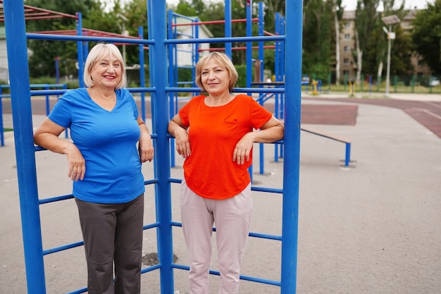 Twee volwassen vrouwen die buiten oefeningen op het stadion doen