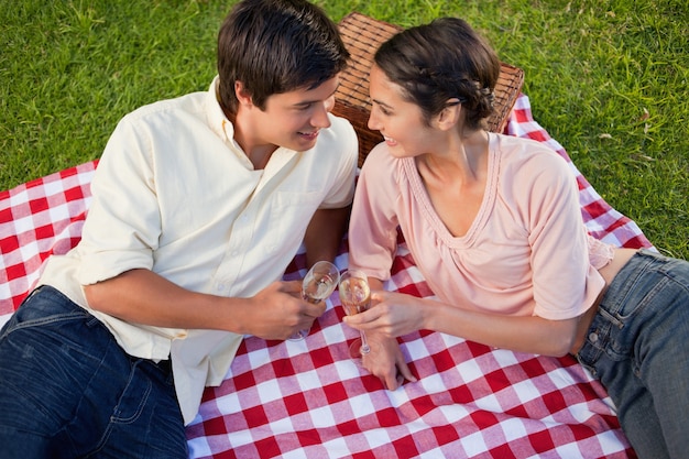 Twee vrienden die naar elkaar tijdens een picknick glimlachen
