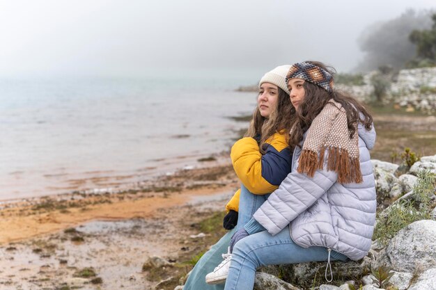 Twee vrienden die samen zitten terwijl ze naar een lagune in een gletsjer kijken