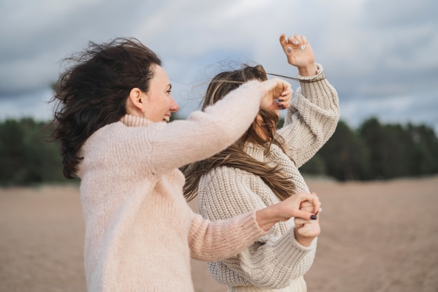 Twee vrienden hebben plezier en genieten van het leven de zussen dansen en lachen heel veel meisjes in warme truien met...