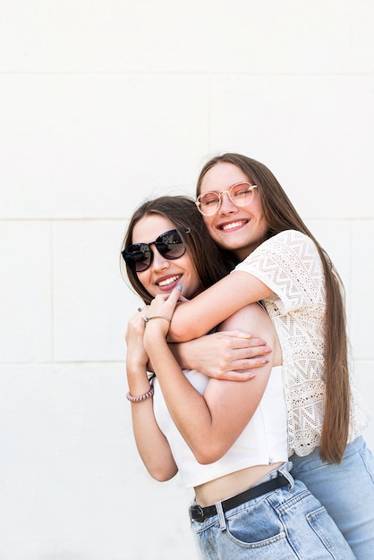 Twee vriendinnen knuffelen buiten in een zomerse dag met plezier