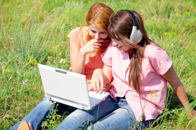 Twee vriendinnen op het platteland met laptop en computer.