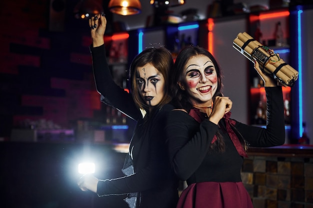 Twee vriendinnen zijn op het thematische halloween-feest in enge make-up en kostuums met tijdbom.