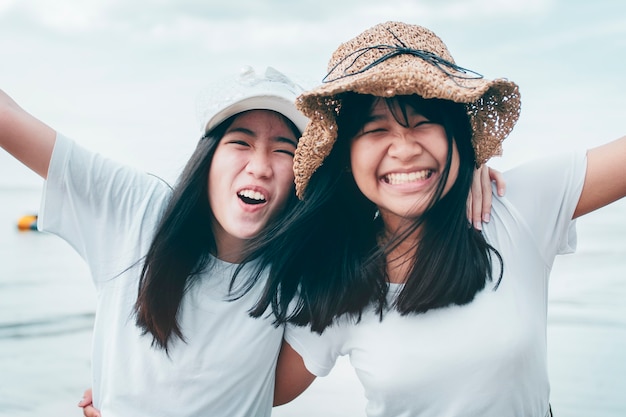 Twee vrolijk aziatisch tienergeluk op vakantie overzees strand