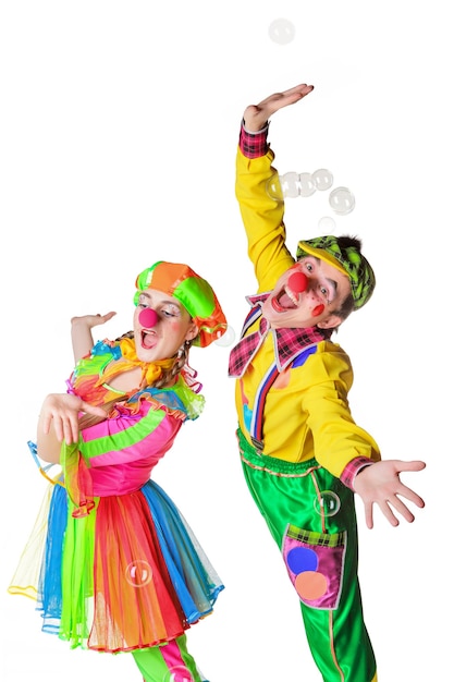 Twee vrolijke clownsvreugde in de zeepbellen die op de witte achtergrond worden geïsoleerd