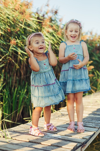 Twee vrolijke Kaukasische meisjes in zomer park.