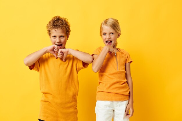 Twee vrolijke kinderen knuffelen mode jeugdvermaak op gekleurde achtergrond ongewijzigd