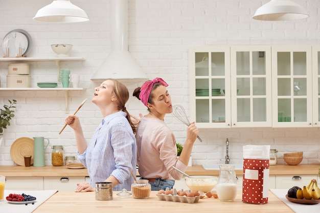 Twee vrolijke vrienden bereiden desserts samen en zingen