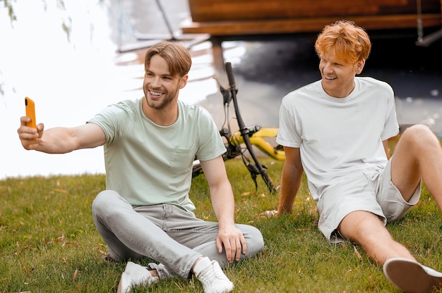 Twee vrolijke vrienden die selfies maken met de smartphone