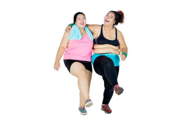 Twee vrolijke vrouwen met overgewicht lachen in de studio