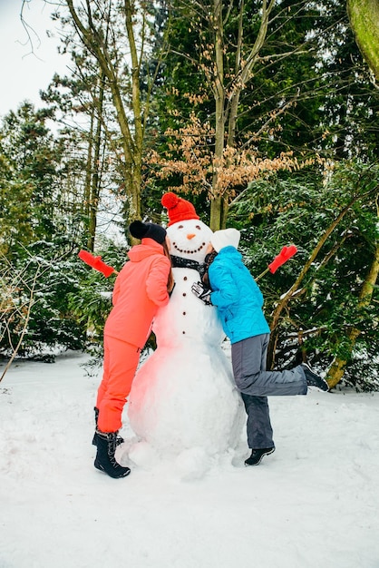 Foto twee vrouw poseren in de buurt van sneeuwpop