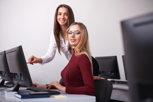 Twee vrouwelijke collega&#39;s in bureau die samenwerken