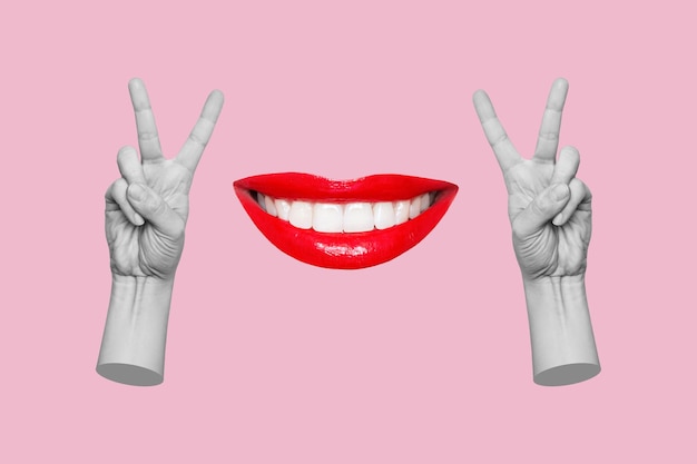 Foto twee vrouwelijke handen die een vredesgebaar tonen en een lachende mond met rode lippenstift op een roze achtergrond