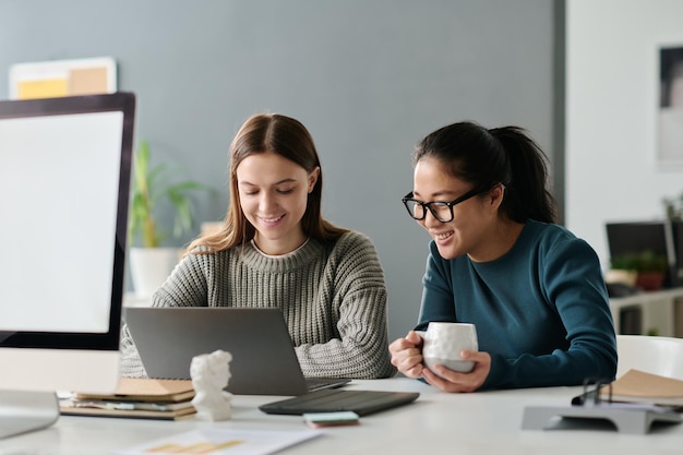 Twee vrouwelijke managers van twee rassen die samenwerken in een kantoor.