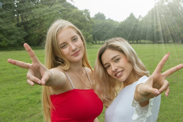 Foto twee vrouwelijke vrienden die plezier hebben in het park.