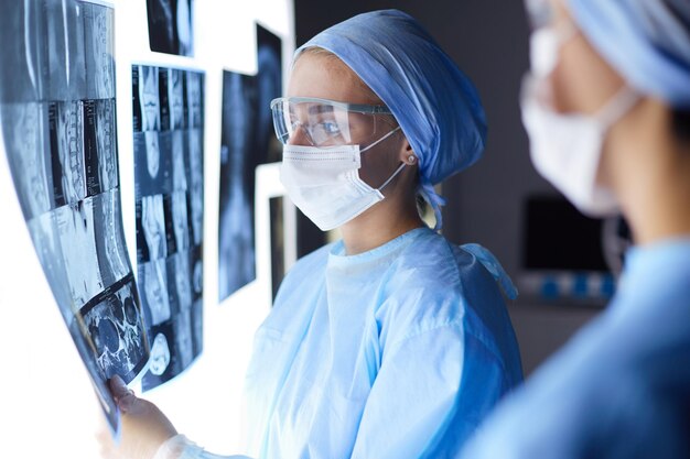 Twee vrouwelijke vrouwelijke artsen die röntgenfoto's in een ziekenhuis bekijken