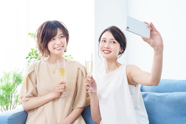 Twee vrouwen die een foto maken van een champagneglas in hun handen