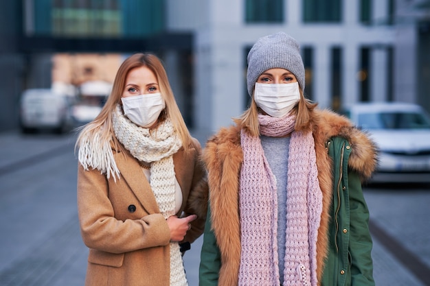 twee vrouwen die gezichtsmaskers dragen en rondhangen in de stad