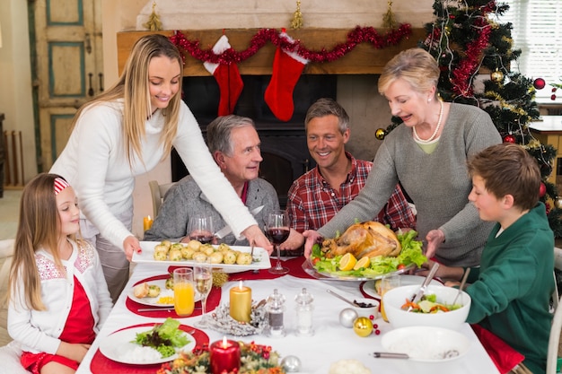 Twee vrouwen die het kerstdiner serveren aan hun familie