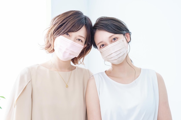 Twee vrouwen die maskers dragen met een kleur dicht bij de huid