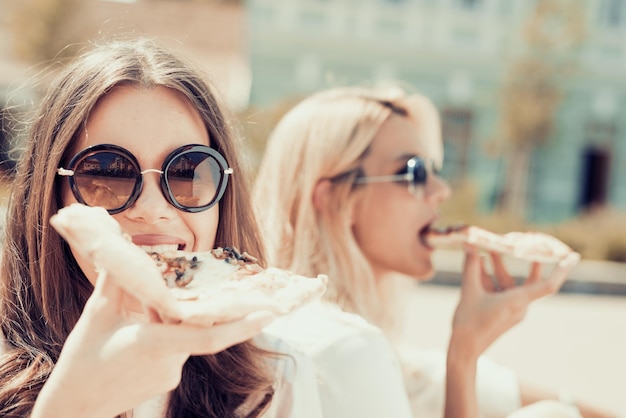 Twee vrouwen die pizza eten