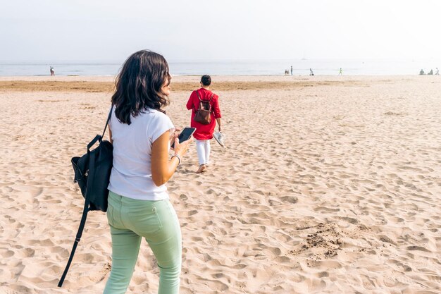 Twee vrouwen die 's middags op het strand lopen