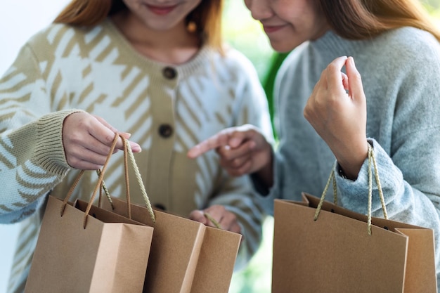 Foto twee vrouwen die samen winkelzakken openen en bekijken