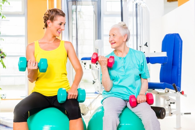 Twee vrouwen die sterktesport doen in fitness gymnastiek