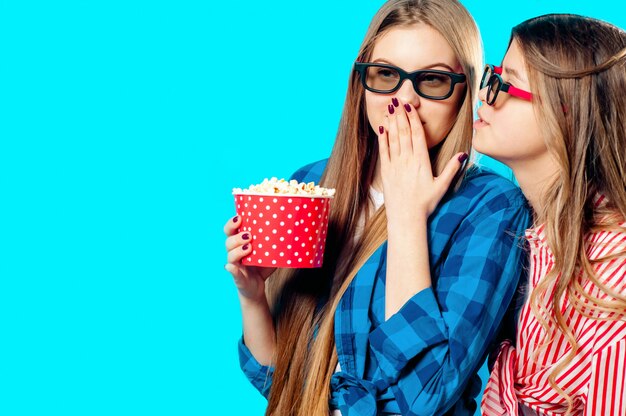 Twee vrouwen eten popcorn in 3D-bril