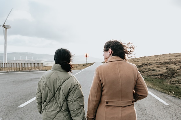 Twee vrouwen houden elkaar handen in een lange weg met kopie ruimte vrijheid en liefde concept