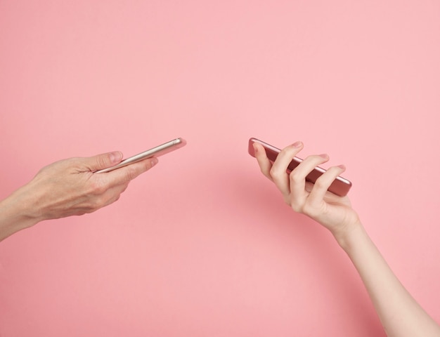 Twee vrouwen houden telefoon op pastelroze