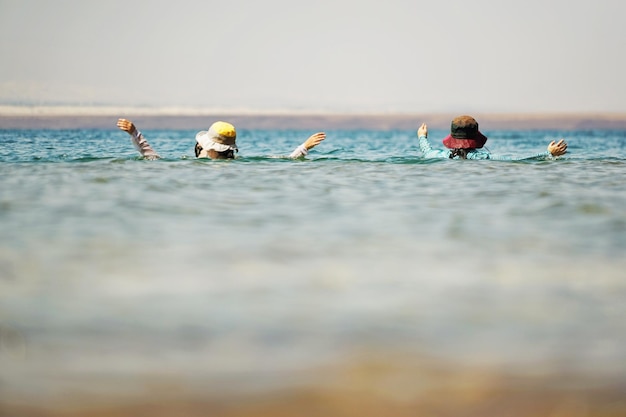 Twee vrouwen in casual kleding in de zee.