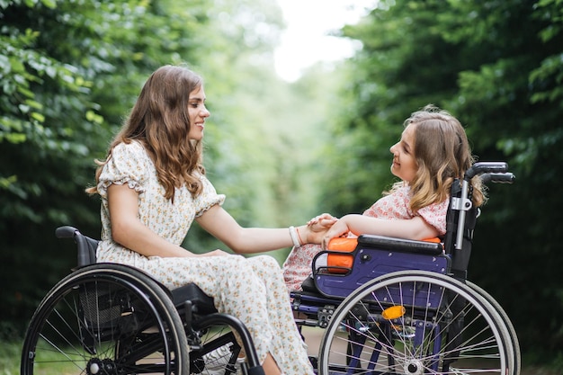 Twee vrouwen in rolstoelen genieten van zomerweer in het park