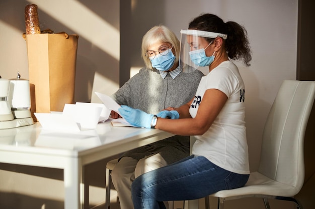 Twee vrouwen met medische maskers onderzoeken documenten