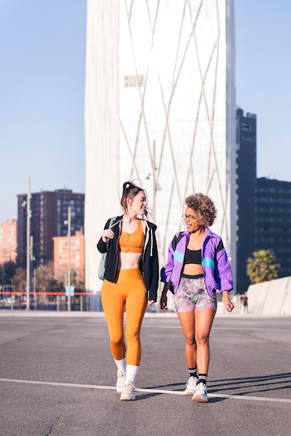 Twee vrouwen met sportkleding die door de stad lopen.