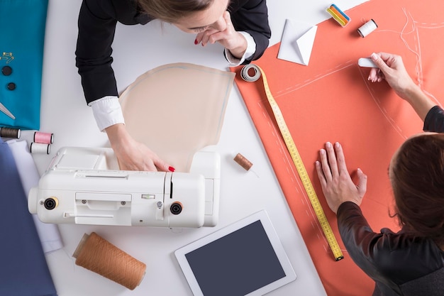 Twee vrouwen naaien aan één bureau