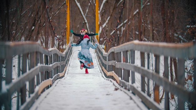 Twee vrouwen rennen op de besneeuwde brug en hebben plezier