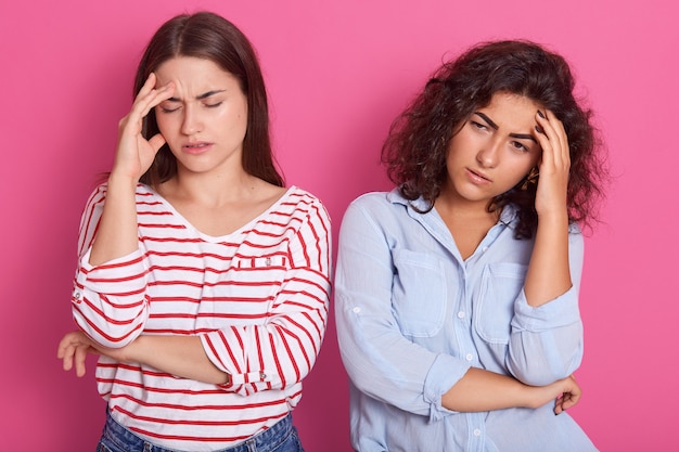 twee vrouwen staan en houden de handen op het voorhoofd, ze zijn boos en denken aan iets belangrijks