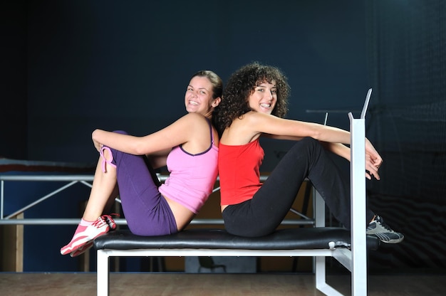 twee vrouwen trainen en strekken zich uit in de fitnessclub