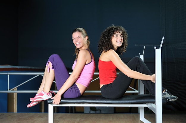 twee vrouwen trainen en strekken zich uit in de fitnessclub