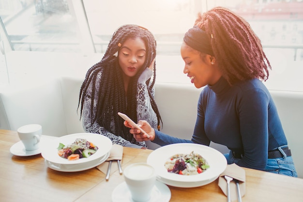 Twee vrouwen zitten in café aan tafel