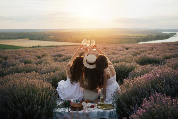 Twee vrouwen zitten in een lavendelveld, waarvan er één de beste manier is om het seizoen te vieren.