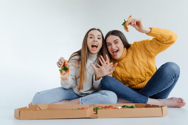 Twee vrouwenvrienden die pizza eten.