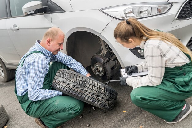 Twee werktuigkundigen die remschijf in auto onderzoeken