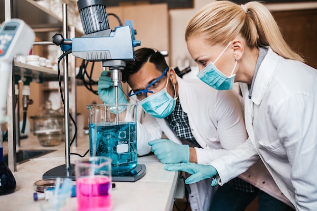 Twee wetenschappers en onderzoekers van middelbare leeftijd werken in een chemisch laboratorium.