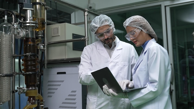 Twee wetenschappers in professioneel uniform werken in laboratorium